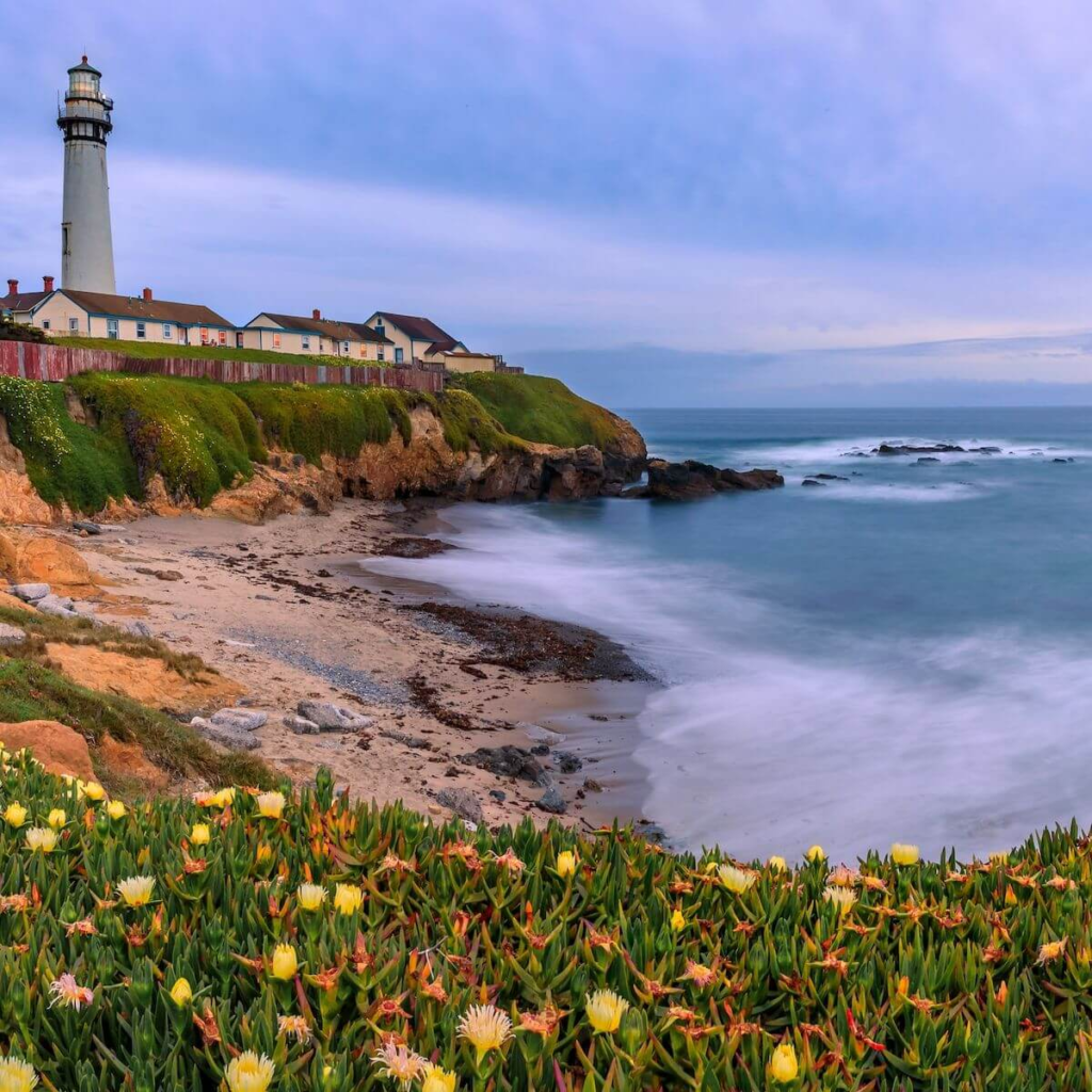 Pescadero coastline near San Francisco with a lighthouse, cliffside cottages, and waves along the rocky shore.
