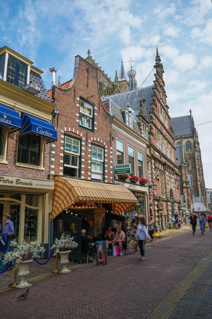 Charming street view in Haarlem, Netherlands with shops, cafes, and historical buildings.