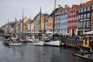 Colorful buildings along the Nyhavn canal in Copenhagen with historic boats docked.