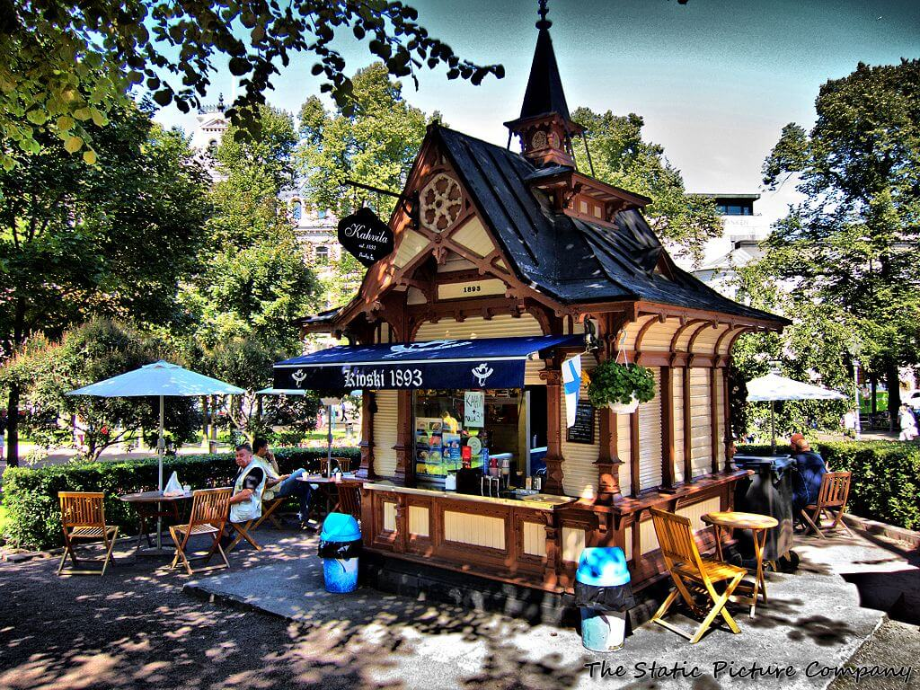Historic wooden coffee kiosk Kahvila 1893 in Helsinki park with outdoor seating.