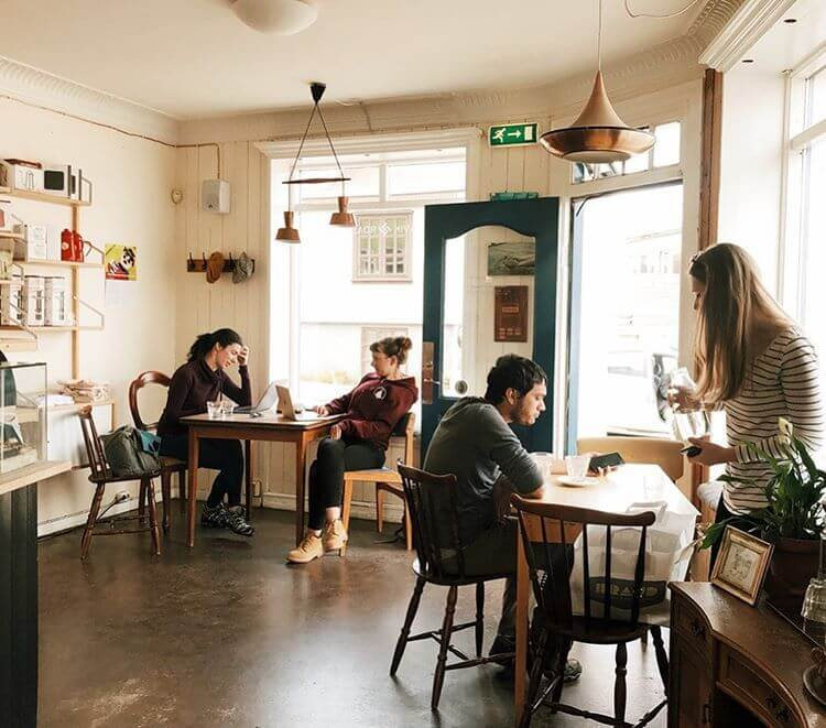 Cozy café in Reykjavík, Iceland with people working and enjoying coffee.