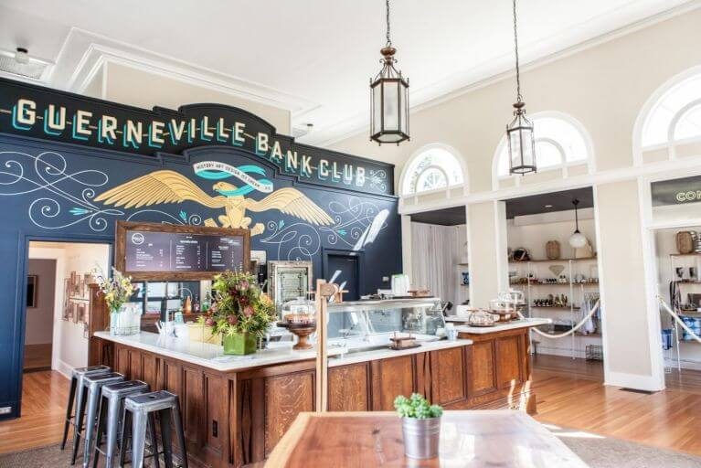 Guerneville Bank Club interior with vintage bar, mural, and modern decor.