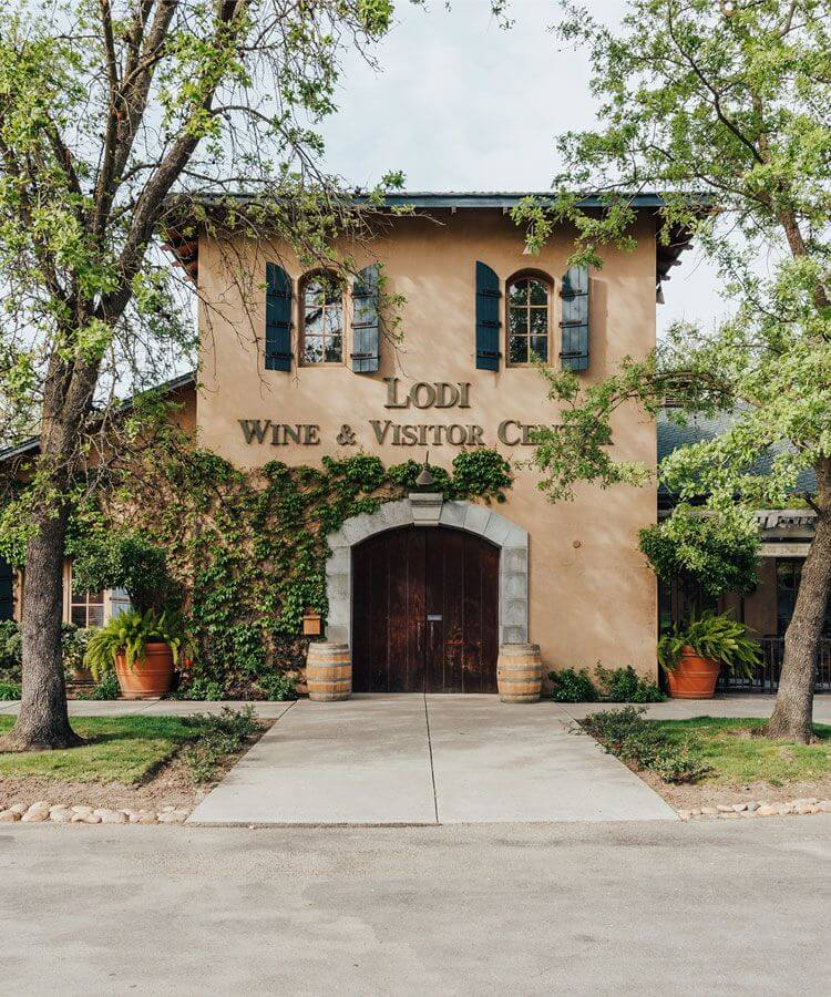 Lodi Wine & Visitor Center building with ivy, trees, and rustic entrance.