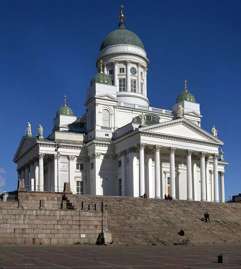 Helsinki Cathedral with its white neoclassical architecture under a clear blue sky.