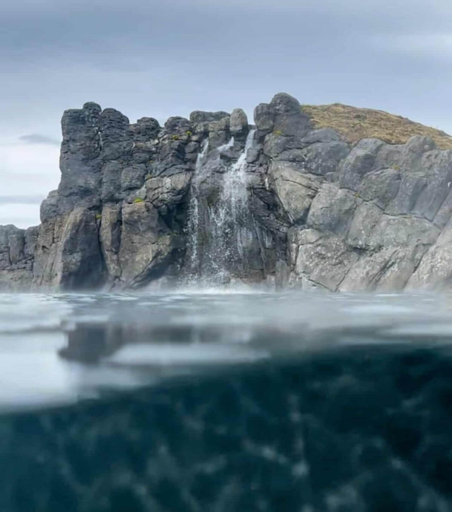 Waterfall cascading over rocky cliffs at Sky Lagoon in Iceland
