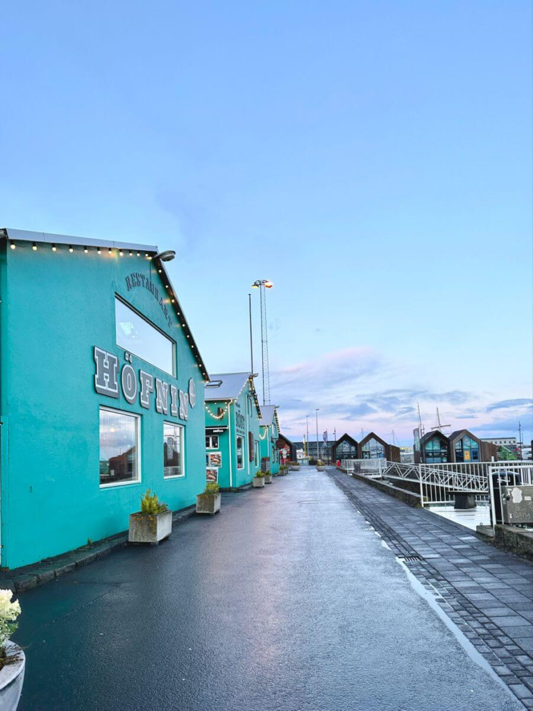 Colorful buildings along Reykjavík’s Old Harbor with a clear sky and waterfront walkway