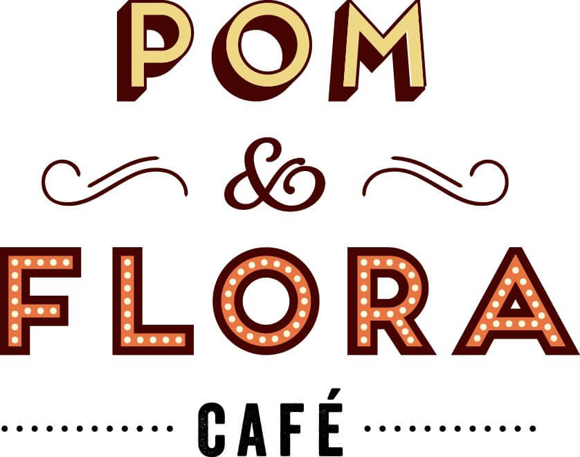 "Logo of Pom & Flora Café with vintage-style lettering and decorative details.