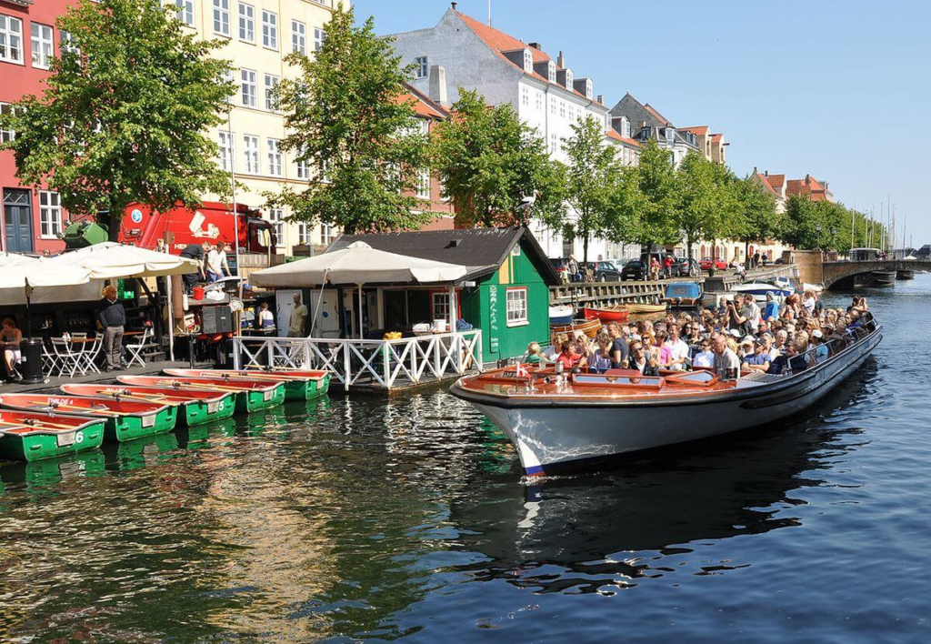 Copenhagen canal tour boat passing colorful waterfront buildings