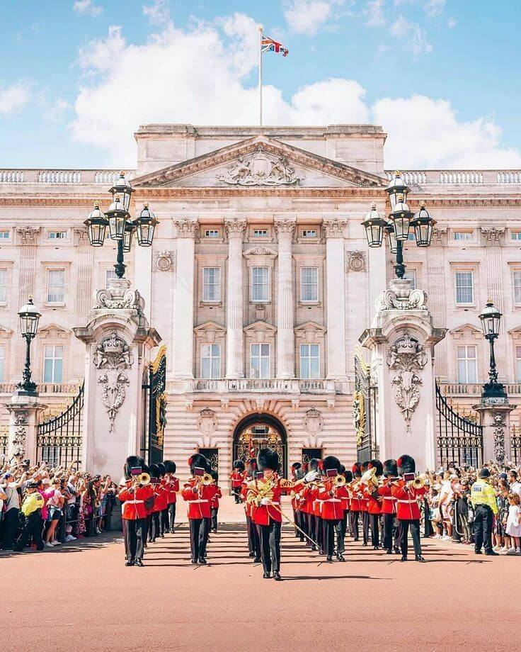 "Changing of the Guards at Buckingham Palace with soldiers in red uniforms."
