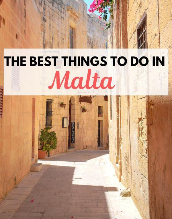 Sunny narrow street in Malta with golden stone buildings and hanging flowers