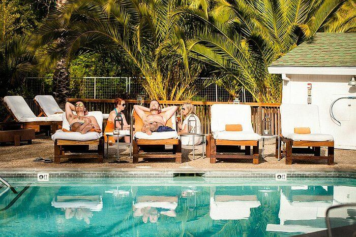 California boutique hotel pool with guests relaxing on loungers