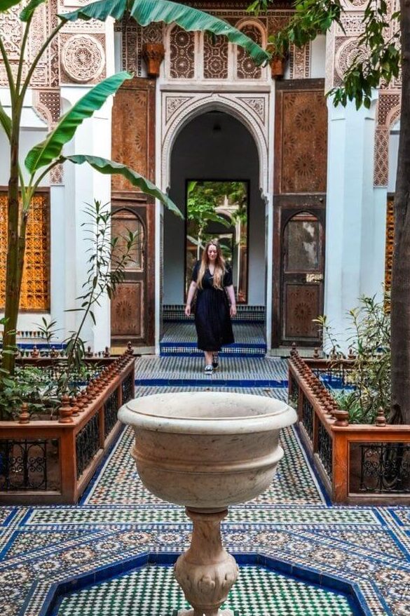 Historic madrasa courtyard in Fes with mosaic tiles and arches